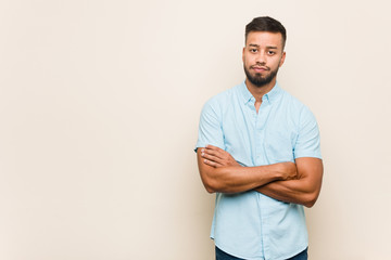 Young south-asian man unhappy looking in camera with sarcastic expression.
