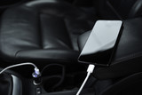 Fototapeta Do akwarium - Mobile phone, smartphone charge battery, charging in the car plug close up