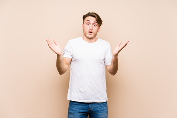 Wall Mural - Young caucasian man posing isolated surprised and shocked.