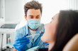 © Тарас Нагирняк - Professional dentist man in mask working with patient in modern clinic.