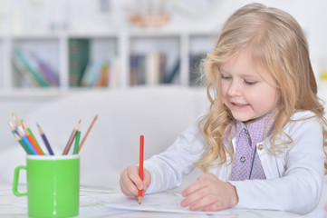 Portrait of cute smiling girl drawing at home