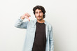 © Asier - Young handsome man against a white background showing a dislike gesture, thumbs down. Disagreement concept.