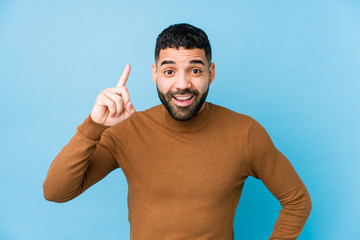 Wall Mural - Young latin man against a blue  background isolated having an idea, inspiration concept.