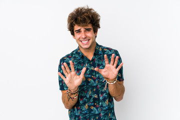 Young caucasian man wearing a flower t-shirt isolated rejecting someone showing a gesture of disgust.