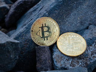 golden bitcoins on the stones. yellow btc on the rocks. gold coin beautiful. Stock photo. Crypto mining currency, miner