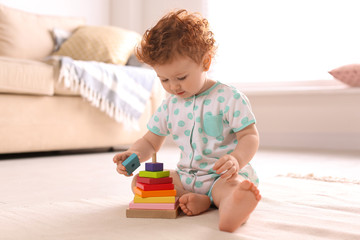 Canvas Print - Cute little child playing with toy on floor at home