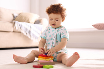 Canvas Print - Cute little child playing with toy on floor at home