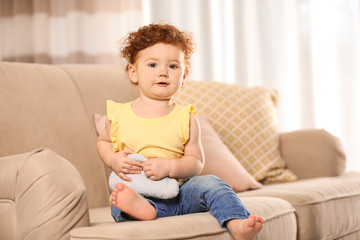 Wall Mural - Portrait of cute little child on sofa at home