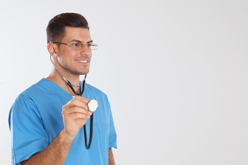 Wall Mural - Doctor with stethoscope on light grey background. Space for text