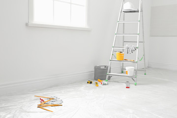 Poster - Stepladder and different tools near wall in room. Interior renovation