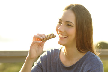 Happy woman is eating a snack outdoors