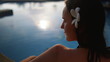 © Goinyk - Woman Relaxing in Thailand Resort Swimming Pool. Back View of Caucasian Brunette Model on Summertime Asian Holiday. Girl with Tropical Flower in Hair Enjoying Koh Phangan Island.