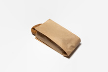 Fresh Black Bread In A Brown Kraft Paper Bag Mockup On White Background.High Resolution Photo.