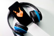 Blauer Funkkopfhörer mit schwarzem Smartphone und brennendem Herz zeigt die feurige Liebe zur Musik und mobilen Musikgenuss digitaler Unterhaltung