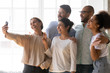 © fizkes - Multi-ethnic friends posing for camera making selfie photo together