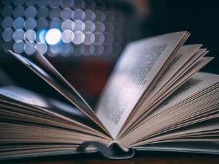 Poster - Closeup shot of an open book with blurred lights in the background