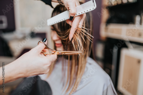 Beautiful young woman getting her haircut by a hairstylist at a beauty salon Poster Mural XXL