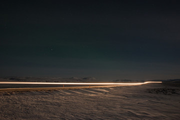 Car light trails at night on a road in Iceland