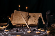 Open Old Book With Magic Spells, Runes, Black Candles On Witch Table. Occult, Esoteric, Divination And Wicca Concept.