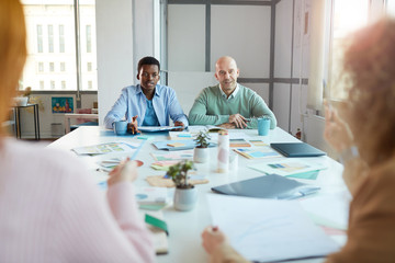Wall Mural - Portrait of two business women sitting opposite two men while negotiating deal in office, copy space