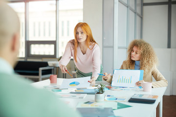 Wall Mural - Portrait of two businesswomen sitting opposite two men while negotiating deal, copy space