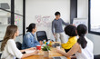 © saksit - Group of Asian businessman writing on whiteboard during business presentation business people team meeting in modern office working design planning and ideas concept