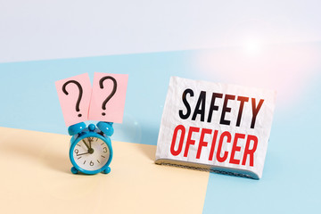 Poster - Writing note showing Safety Officer. Business concept for a demonstrating responsible for ensuring safety regulations Alarm clock beside a Paper sheet placed on pastel backdrop