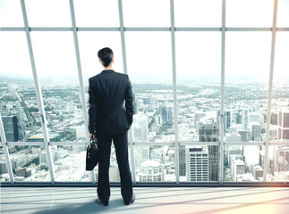 Canvas Print - Businessman with case standing in office