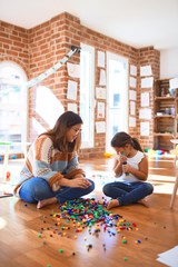 Poster - Beautiful teacher and toddler playing with building blocks toy around lots of toys at kindergarten