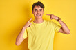 © Krakenimages.com - Teenager boy wearing yellow t-shirt over isolated background smiling cheerful showing and pointing with fingers teeth and mouth. Dental health concept.