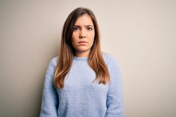 Wall Mural - Beautiful young woman wearing casual winter sweater standing over isolated background skeptic and nervous, frowning upset because of problem. Negative person.