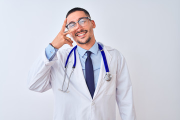 Sticker - Young doctor man wearing stethoscope over isolated background Doing peace symbol with fingers over face, smiling cheerful showing victory