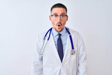 Wall Mural - Young doctor man wearing stethoscope over isolated background afraid and shocked with surprise and amazed expression, fear and excited face.