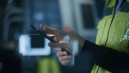 Poster - Professional Engineer Wearing Safety Vest Uses Digital Tablet Computer. Slow Motion Focus on Hands Using Gestures. Working in Industrial Facility with High Tech Machinery.