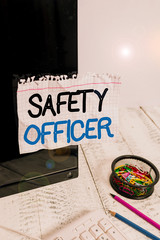 Poster - Word writing text Safety Officer. Business photo showcasing a demonstrating responsible for ensuring safety regulations Note paper taped to black computer screen near keyboard and stationary