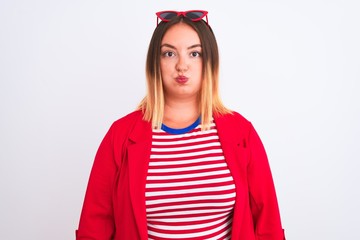 Poster - Young beautiful woman wearing striped t-shirt and jacket over isolated white background puffing cheeks with funny face. Mouth inflated with air, crazy expression.