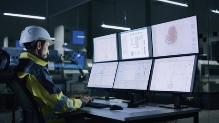 Wall Mural - Industry 4.0 Modern Factory: Facility Operator Controls Workshop Production Line, Uses Computer with Screens Showing Complex UI of Machine Operation Processes, Controllers, Machinery Blueprints