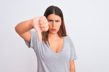 Poster - Portrait of beautiful young woman standing over isolated white background looking unhappy and angry showing rejection and negative with thumbs down gesture. Bad expression.