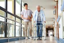 Asian Old Man Walking With A Walker In Rehab Center
