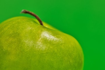 Granny Smith apple up close in foreground, selective focus artistic effect. Partial subject, abstract with green background and room for text.