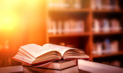 Poster - Stack of books in the library and blur bookshelf background