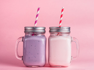 Strawberry and blueberry smoothie on pink