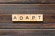 ADAPT word written on wood block. ADAPT text on wooden table for your desing, concept