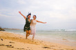© TheVisualsYouNeed - happy couple of attractive Asian Chinese women running crazy together at the beach enjoying holidays in gay lesbian love or close girlfriends relationship concept