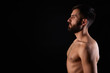 © Jorge - Caucasian young man with beard, serious, shirtless, muscular body, on black background in profile, horizontal
