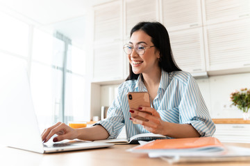 Wall Mural - Happy brunette young woman using laptop computer