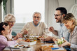 © Drazen - Happy extended family enjoying in lunch at dining table.
