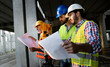 © NDABCREATIVITY - Confident team of architects and engineers working together on construction site