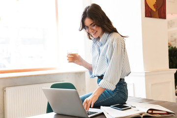 Sticker - Attractive young brunette woman studying in the cafe indoors