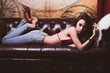 © Sasils Production - Cute asian woman laying on sofa. With shoes. For seductive sensuality and provocative desire concept. Vintage filter look.